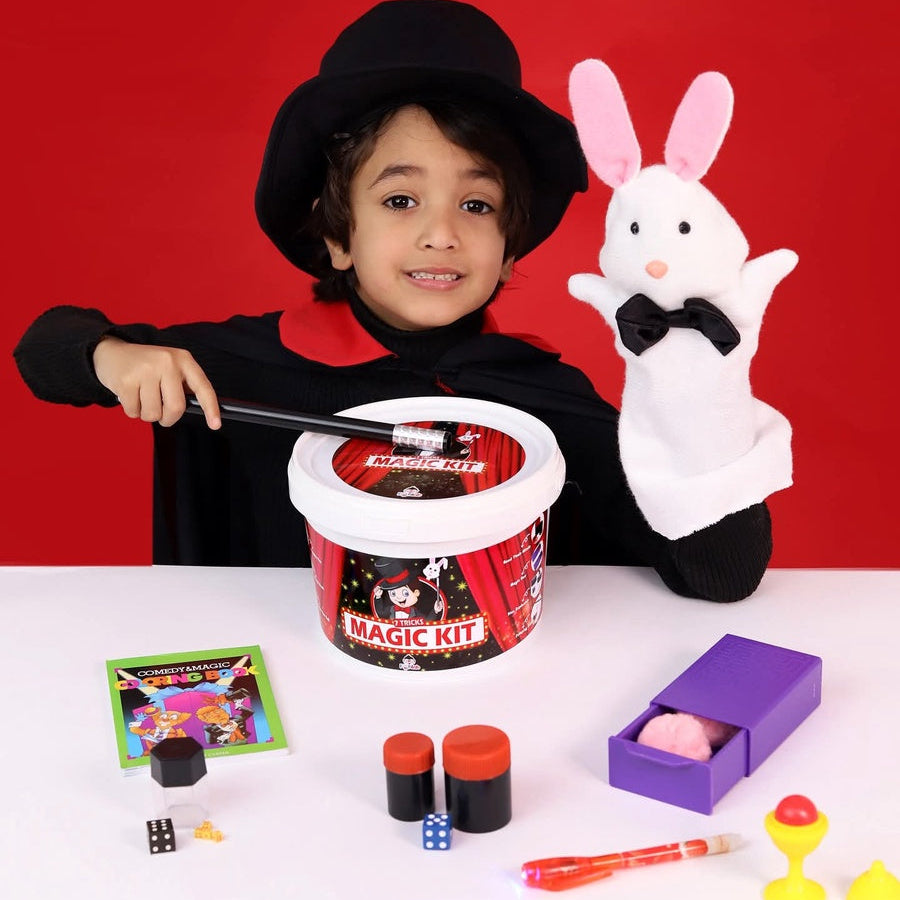 Child with a magic kit and rabbit toy against a red background