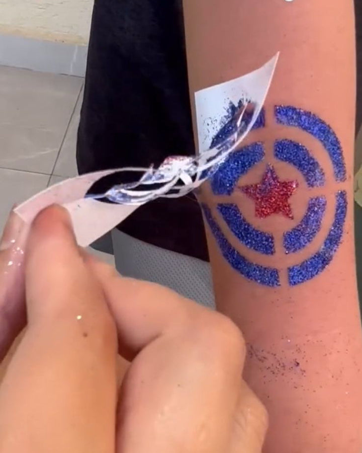 Glitter tattoo making kit application on a person's arm with a star design.